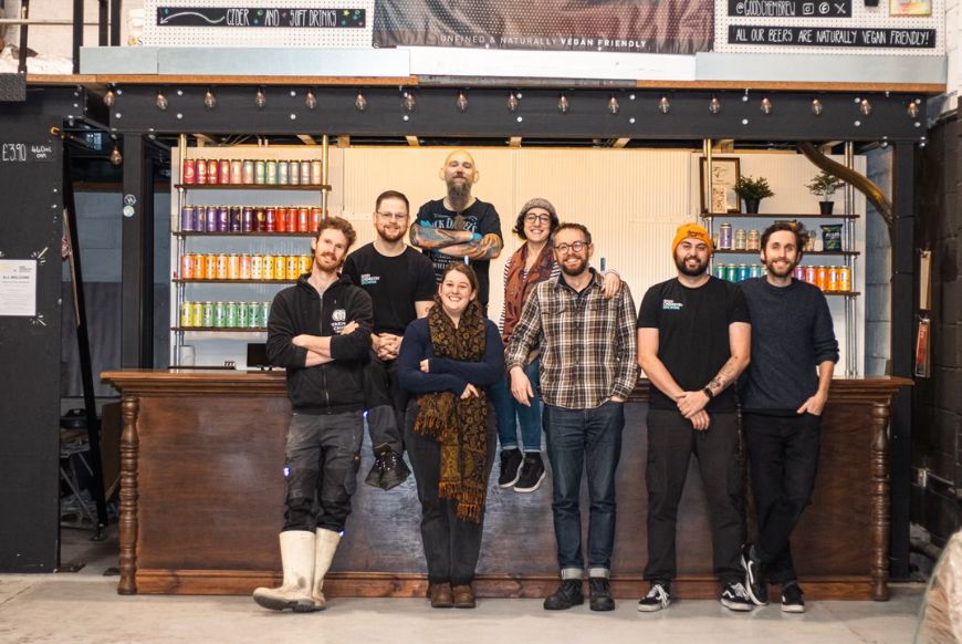 a group pf people posing in front of a bar